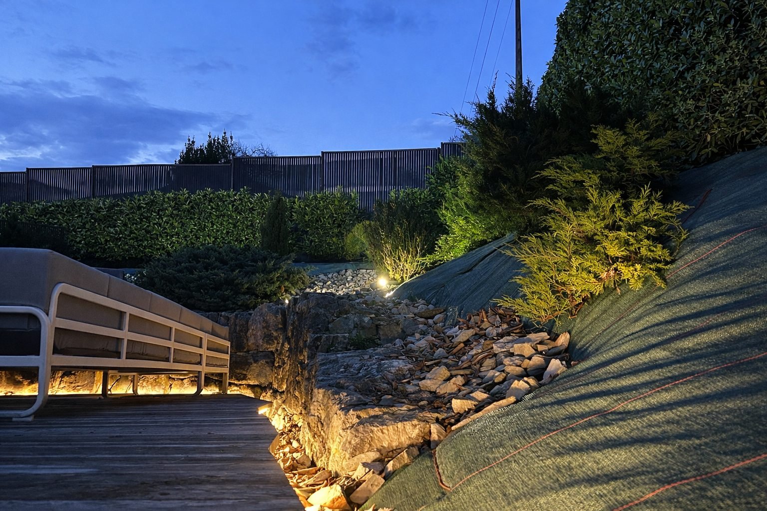 Terrasse et jardin alpin mis en lumière à l'heure bleue par Alpine Lighting, rocaille et massifs soulignés